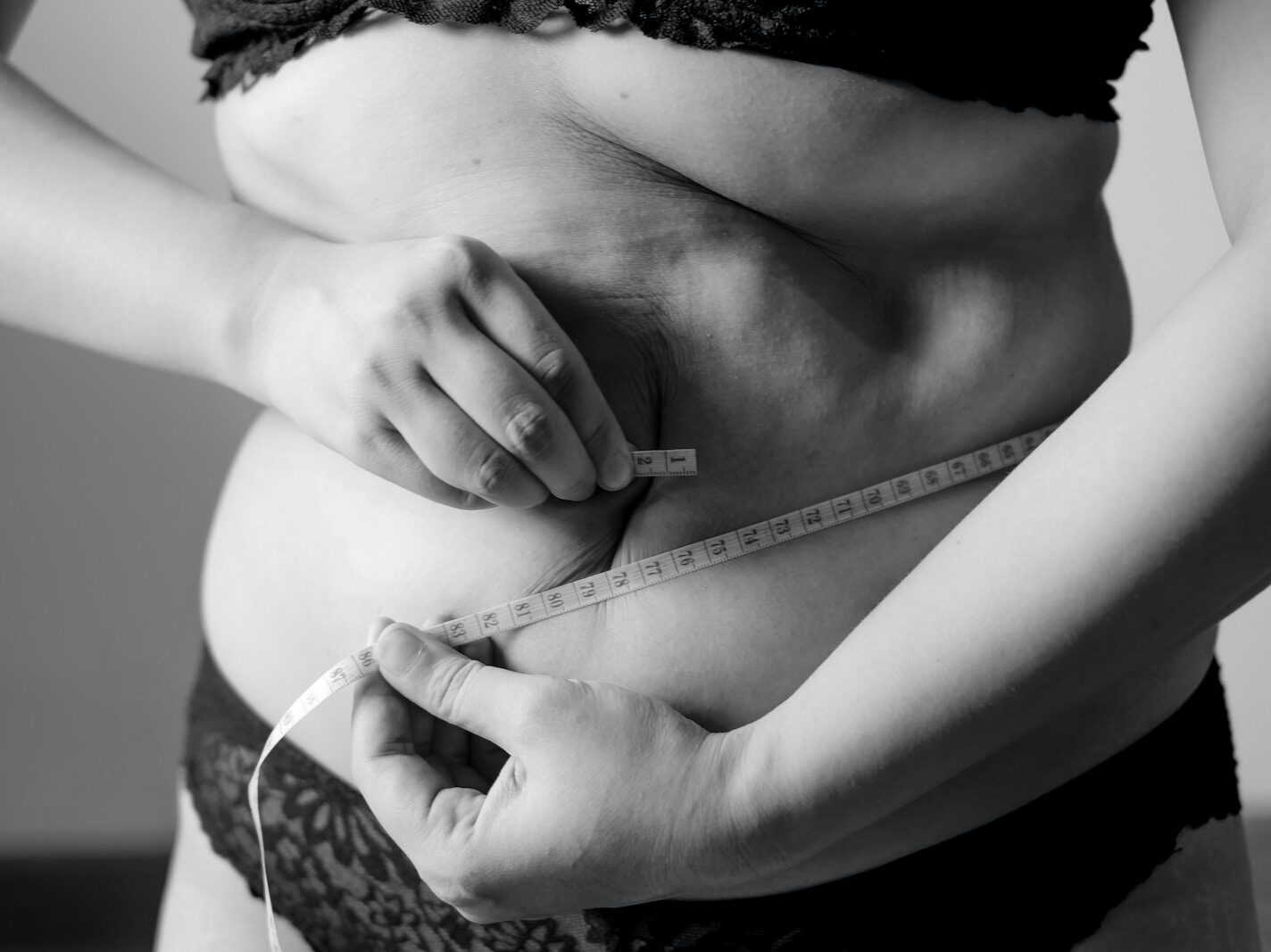 grayscale photo of woman holding her breast